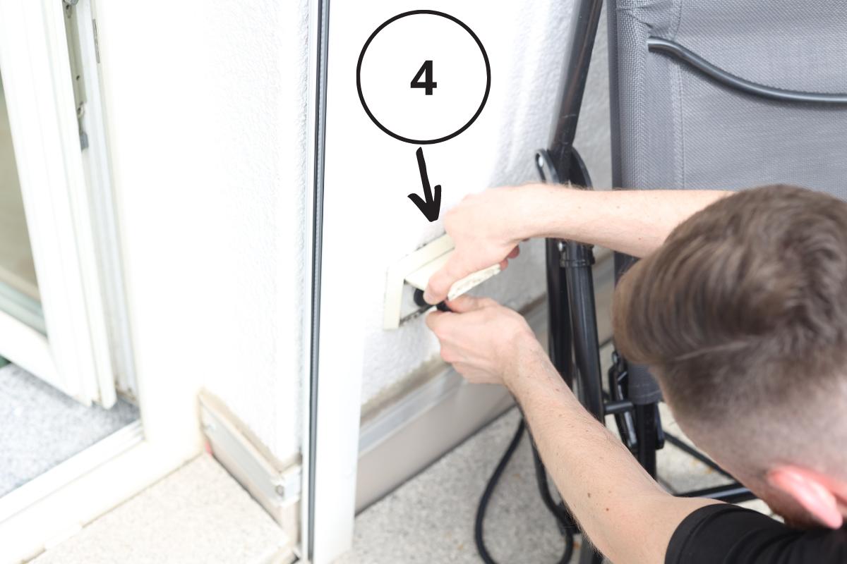 Das Stromkabel vom Wechselrichter wird vor der Außensteckdose gehalten und eingesteckt, was der letzte Punkt in der Reihenfolge beim Balkonkraftwerk Speicher nachrüsten ist.